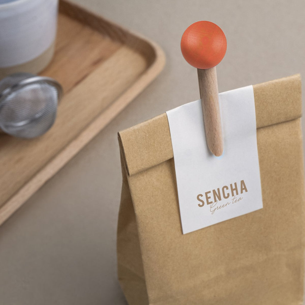 brown and orange wooden bag clip on paper bag with the words sencha on it