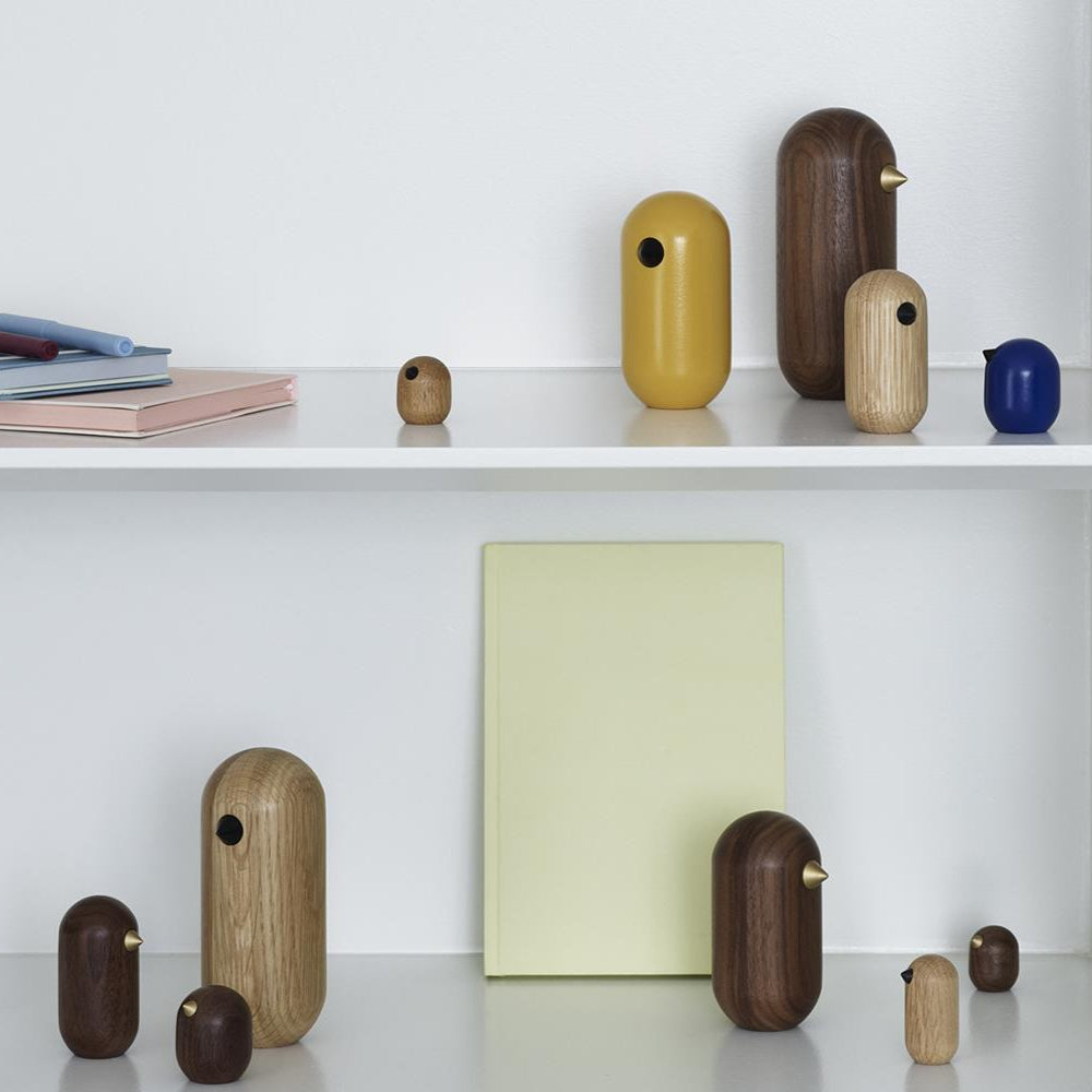 Collection of wooden and ceramic vases on a white shelf with books and a bowl.