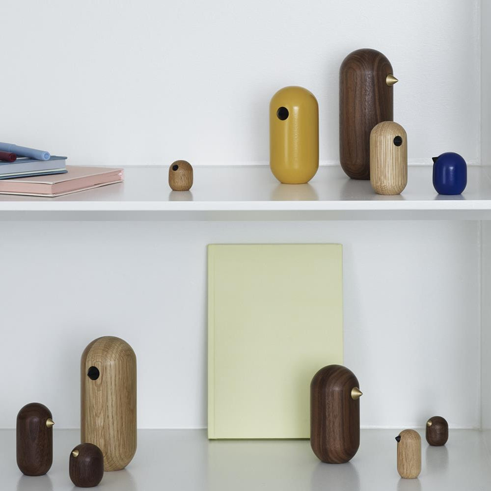 Collection of wooden and ceramic vases on a white shelf with books and a bowl.