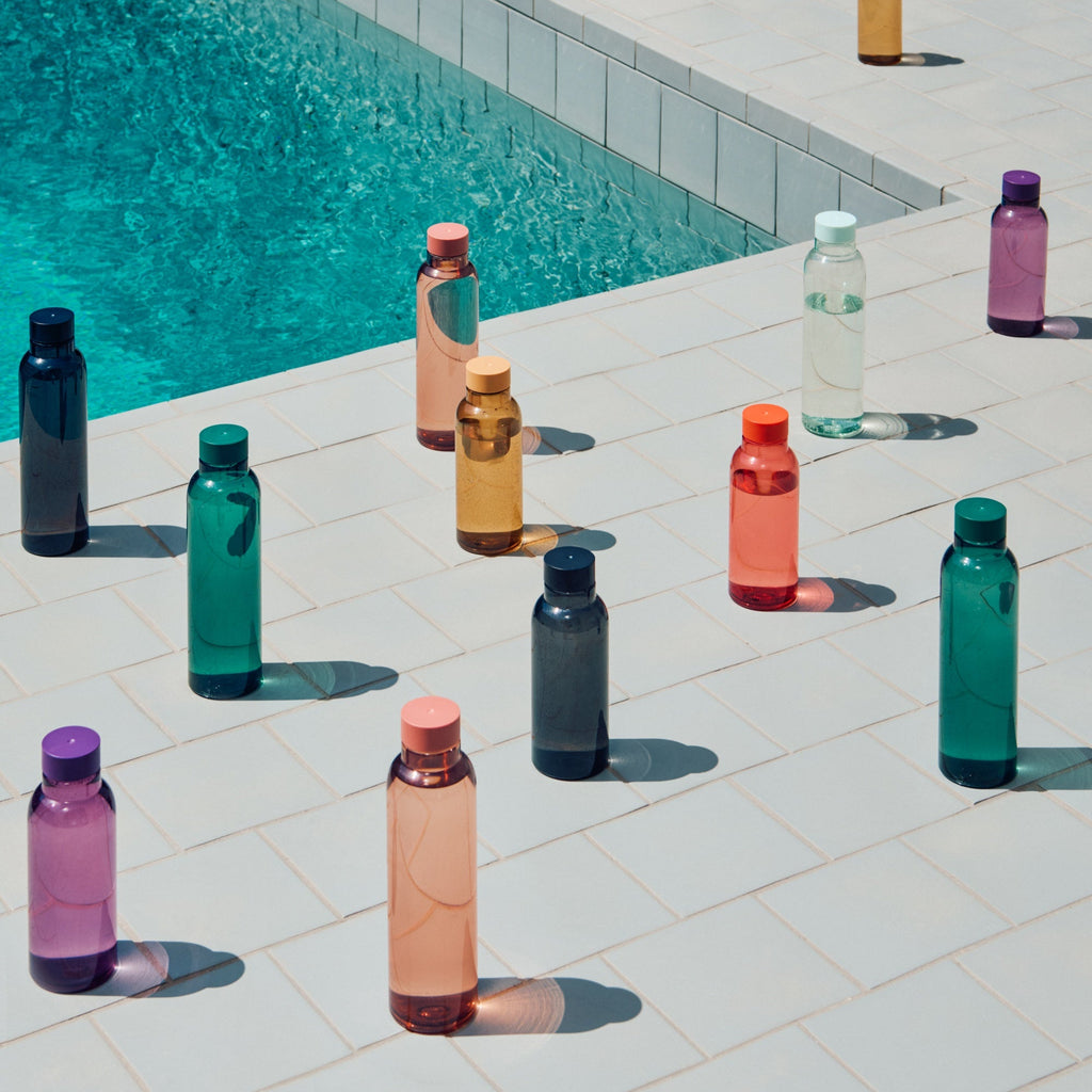 Colorful water bottles arranged by a pool